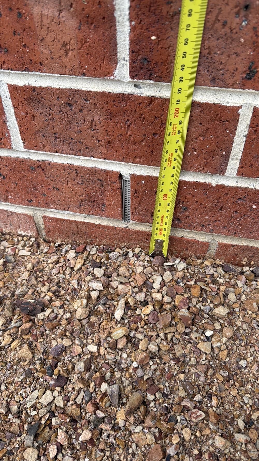 Weep holes sitting too close to the ground, below the required clearance, found during a building inspection in Wollert